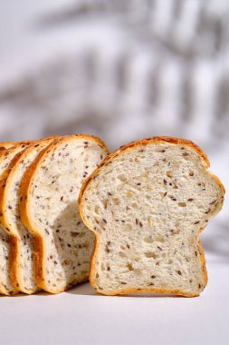 Hafif bir arka planda tabakta taze ekmek ve kızarmış ekmek. Tatlı hamur işleri. Gıda ve beslenme konsepti