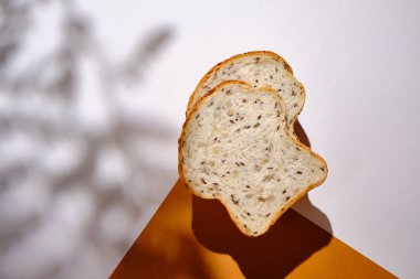 Hafif bir arka planda tabakta taze ekmek ve kızarmış ekmek. Tatlı hamur işleri. Gıda ve beslenme konsepti