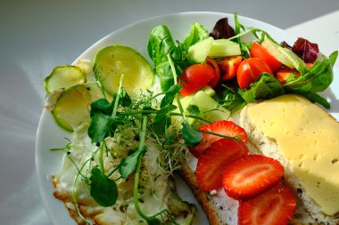 Çilekli, peynirli, yeşil salatalı ve yumurtalı lezzetli bir kahvaltı sandviçi. Düzgün beslenme ve sağlık kavramı