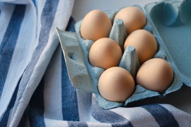 Tavuk yumurtalı karton kutular. Masada pişmemiş yumurtalarla kutular. Doğal organik tarım ürünü. Paskalya tatiline hazırlanıyorum. Taze yemek teslimatı, karton paket. Yemek pişirmek için ham malzeme.