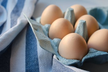 Tavuk yumurtalı karton kutular. Masada pişmemiş yumurtalarla kutular. Doğal organik tarım ürünü. Paskalya tatiline hazırlanıyorum. Taze yemek teslimatı, karton paket. Yemek pişirmek için ham malzeme.