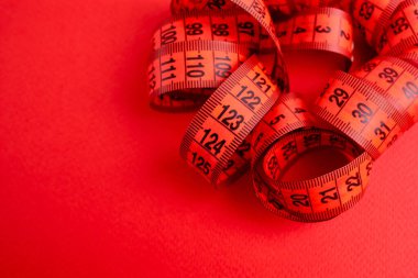 Beyaz arka planda kırmızı şerit. Uzunluk ve hacim ölçme aracı. Giysi endüstrisinde veya insan vücudunun hacmini ölçmek için bant