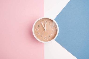 Renkli bir arka planda beyaz çalar saat. Moda minimalist tarzı. Zaman, iş ve teknoloji kavramı. Düz kompozisyon. Yukarıdan görüntüle 
