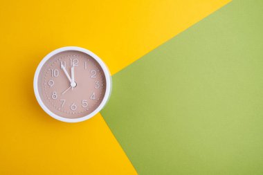 Renkli bir arka planda beyaz çalar saat. Moda minimalist tarzı. Zaman, iş ve teknoloji kavramı. Düz kompozisyon. Yukarıdan görüntüle 