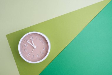 Renkli bir arka planda beyaz çalar saat. Moda minimalist tarzı. Zaman, iş ve teknoloji kavramı. Düz kompozisyon. Yukarıdan görüntüle 