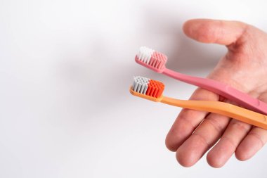 Arka planda diş fırçasıyla el ele tutuşmak. Diş temizliği ve hijyen. Diş sağlığı ve güzellik konsepti