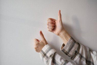 Kadın eli, arka planda iyi ya da mükemmel gösteren baş parmaklar gösteriyor. Jestler. Duygular