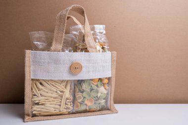 Makarna için temiz plastik torba. Çiğ makarna arkaplanı yakın plan. Farklı renkte makarna ve erişte çeşitleri. İtalyan mutfağı konsepti. Farklı ham makarna koleksiyonu