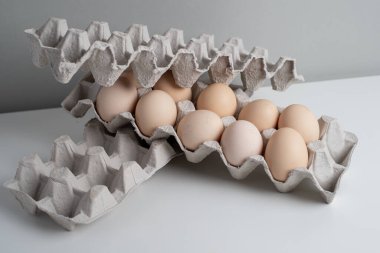 Tavuk yumurtalı karton kutular. Masada pişmemiş yumurtalarla kutular. Doğal organik tarım ürünü. Paskalya tatiline hazırlanıyorum. Taze yemek teslimatı, karton paket. Yemek pişirmek için ham malzeme.