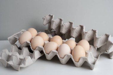Tavuk yumurtalı karton kutular. Masada pişmemiş yumurtalarla kutular. Doğal organik tarım ürünü. Paskalya tatiline hazırlanıyorum. Taze yemek teslimatı, karton paket. Yemek pişirmek için ham malzeme.