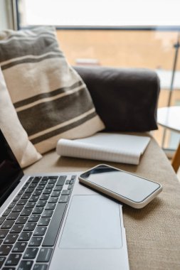 Bilgisayarı ve akıllı telefonu olan bir ofis masası. Birkaç aletli ahşap masa. Uzaktan çalışmak için. Evden çalışıyorum. İş geçmişi. Ofis evde.
