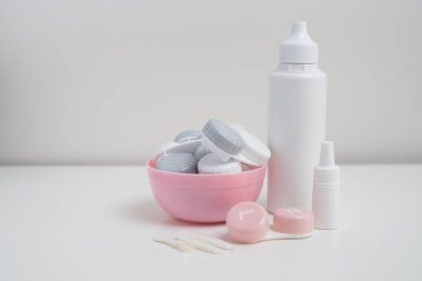 Kontakt lensler, çanta ve solüsyonlu şişe ve beyaz arka planda göz damlası. Göz sağlığı ve bakımı, görüş, göz bilimi konsepti, yakın çekim