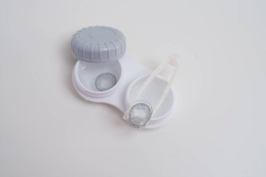 Kontakt lensler, çanta ve solüsyonlu şişe ve beyaz arka planda göz damlası. Göz sağlığı ve bakımı, görüş, göz bilimi konsepti, yakın çekim