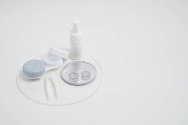 Kontakt lensler, çanta ve solüsyonlu şişe ve beyaz arka planda göz damlası. Göz sağlığı ve bakımı, görüş, göz bilimi konsepti, yakın çekim