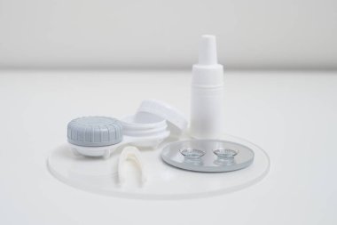 Kontakt lensler, çanta ve solüsyonlu şişe ve beyaz arka planda göz damlası. Göz sağlığı ve bakımı, görüş, göz bilimi konsepti, yakın çekim