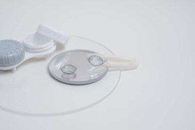 Kontakt lensler, çanta ve solüsyonlu şişe ve beyaz arka planda göz damlası. Göz sağlığı ve bakımı, görüş, göz bilimi konsepti, yakın çekim