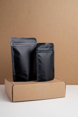 Arka planda çay, kahve, atıştırmalık ve kozmetik ürünleri için siyah paketler var. Ürünler için markalaşma ve paketleme modeli. Toparlanıyoruz. Satılık ürünler. Boş, model.