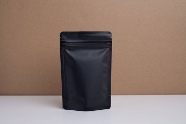 Arka planda çay, kahve, atıştırmalık ve kozmetik ürünleri için siyah paketler var. Ürünler için markalaşma ve paketleme modeli. Toparlanıyoruz. Satılık ürünler. Boş, model.