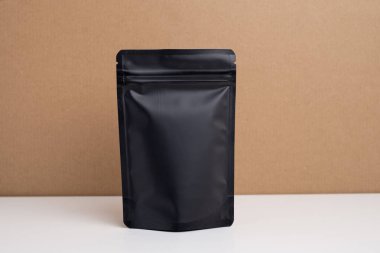 Arka planda çay, kahve, atıştırmalık ve kozmetik ürünleri için siyah paketler var. Ürünler için markalaşma ve paketleme modeli. Toparlanıyoruz. Satılık ürünler. Boş, model.