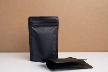 Arka planda çay, kahve, atıştırmalık ve kozmetik ürünleri için siyah paketler var. Ürünler için markalaşma ve paketleme modeli. Toparlanıyoruz. Satılık ürünler. Boş, model.