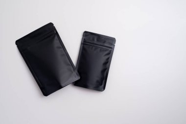 Arka planda çay, kahve, atıştırmalık ve kozmetik ürünleri için siyah paketler var. Ürünler için markalaşma ve paketleme modeli. Toparlanıyoruz. Satılık ürünler. Boş, model.