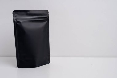 Arka planda çay, kahve, atıştırmalık ve kozmetik ürünleri için siyah paketler var. Ürünler için markalaşma ve paketleme modeli. Toparlanıyoruz. Satılık ürünler. Boş, model.