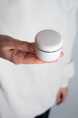 Bir kızın ellerinde bir kavanoz kaplıca kremi. Cilt bakımı. Eller için tıbbi ve dermatolojik kozmetik ürünleri. Bir kadının güzelliği ve sağlığı. Ceset için spa tedavisi. Doğal krem kaplamalı kap.