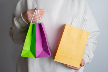 Elinde alışveriş paketi olan bir kadın. Kese kağıdı. Mağazada indirim var. Müşteri satın alma hediyesi. Kara Cuma indirimi. Özel tatil indirimi, indirim. Piyasada bir kadın
