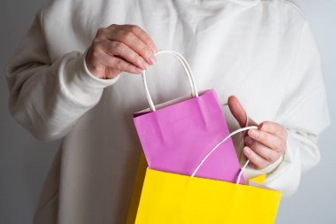 Elinde alışveriş paketi olan bir kadın. Kese kağıdı. Mağazada indirim var. Müşteri satın alma hediyesi. Kara Cuma indirimi. Özel tatil indirimi, indirim. Piyasada bir kadın