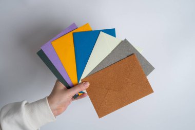 Kadın el kâğıdı zarf ve kutu tutuyor. Yeni posta, mesaj. Posta servisi. Genç kız mektup ya da paket istiyor. Boş zarf, boş alan. İnsanlarla iletişim. Zarf kapatma