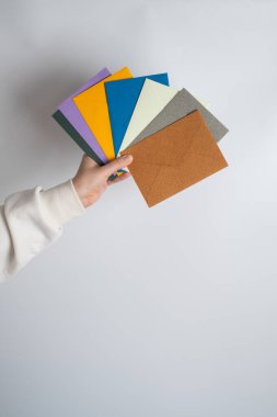 Kadın el kâğıdı zarf ve kutu tutuyor. Yeni posta, mesaj. Posta servisi. Genç kız mektup ya da paket istiyor. Boş zarf, boş alan. İnsanlarla iletişim. Zarf kapatma