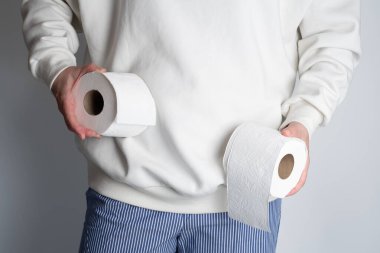 Kadının elleri yumuşak beyaz tuvalet kağıdı rulosunu tutuyor. Hijyen konsepti. Yakın plan.