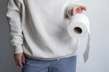 Kadının elleri yumuşak beyaz tuvalet kağıdı rulosunu tutuyor. Hijyen konsepti. Yakın plan.