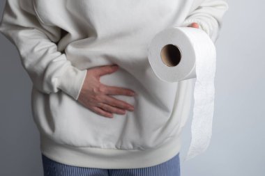 Ağrısı olan bir kadın, karın ağrısı, mide ve tuvalet kağıdı rulosu, mide ağrısı ve sindirim sorunları, mide iltihabı veya ishal, mide problemi olan bir kız. Arkaplanda izole