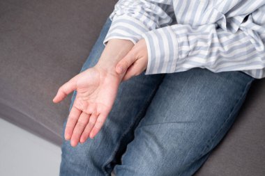 Kadın vücudunda acı hissediyor, diziyle ve elleriyle vücuduna dokunuyor. Uzuv yaralanması. Sağlık kavramı