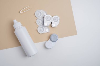 Kontakt lensler, çanta ve solüsyonlu şişe ve beyaz arka planda göz damlası. Göz sağlığı ve bakımı, görüş, göz bilimi konsepti, yakın çekim 