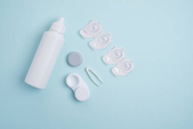 Kontakt lensler, çanta ve solüsyonlu şişe ve beyaz arka planda göz damlası. Göz sağlığı ve bakımı, görüş, göz bilimi konsepti, yakın çekim 