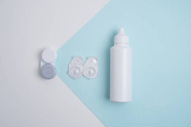 Kontakt lensler, çanta ve solüsyonlu şişe ve beyaz arka planda göz damlası. Göz sağlığı ve bakımı, görüş, göz bilimi konsepti, yakın çekim 