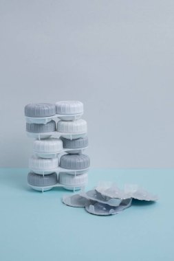 Kontakt lensler, çanta ve solüsyonlu şişe ve beyaz arka planda göz damlası. Göz sağlığı ve bakımı, görüş, göz bilimi konsepti, yakın çekim 