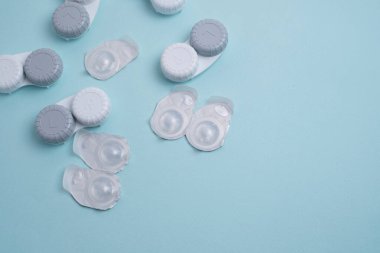 Kontakt lensler, çanta ve solüsyonlu şişe ve beyaz arka planda göz damlası. Göz sağlığı ve bakımı, görüş, göz bilimi konsepti, yakın çekim 