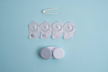 Kontakt lensler, çanta ve solüsyonlu şişe ve beyaz arka planda göz damlası. Göz sağlığı ve bakımı, görüş, göz bilimi konsepti, yakın çekim 