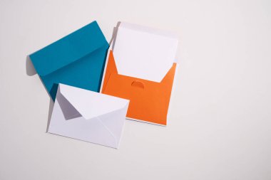 Hafif arka planda kağıt zarflar. Yeni posta, bir mesaj yaz. Gönder ve al. Posta servisi. Boş zarf, boş alan. İnsanlarla iletişim, evrak işleri. Zarfı kapat.