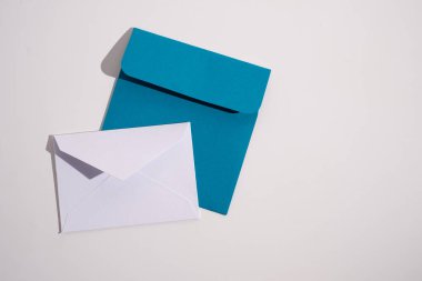 Hafif arka planda kağıt zarflar. Yeni posta, bir mesaj yaz. Gönder ve al. Posta servisi. Boş zarf, boş alan. İnsanlarla iletişim, evrak işleri. Zarfı kapat.