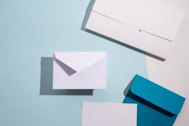 Hafif arka planda kağıt zarflar. Yeni posta, bir mesaj yaz. Gönder ve al. Posta servisi. Boş zarf, boş alan. İnsanlarla iletişim, evrak işleri. Zarfı kapat.