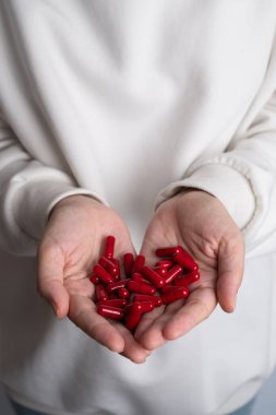 Kadın elinde bir avuç dolusu hap ya da vitamin tutuyor. Vitamin ya da ilaç alıyorum. Sağlık, ilaç, eczane, hastalık önleme kavramı. Elinde bir kavanoz hap ya da vitamin vardı.