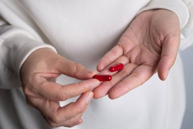 Kadın elinde bir avuç dolusu hap ya da vitamin tutuyor. Vitamin ya da ilaç alıyorum. Sağlık, ilaç, eczane, hastalık önleme kavramı. Elinde bir kavanoz hap ya da vitamin vardı.