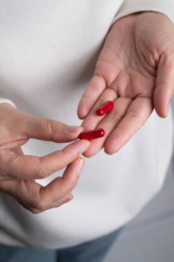 Kadın elinde bir avuç dolusu hap ya da vitamin tutuyor. Vitamin ya da ilaç alıyorum. Sağlık, ilaç, eczane, hastalık önleme kavramı. Elinde bir kavanoz hap ya da vitamin vardı.
