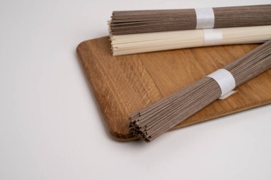 Bir paket kuru soba, çiğ karabuğday ve pirinç eriştesi, pişmemiş karabuğday makarnası, beyaz arka planda glütensiz soba spagettisi..