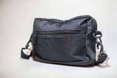 Beyaz arka planda mavi deri çantalı siyah sırt çantası..