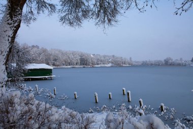 Bir kış gününün güzelliği Litvanya 'nın Trakai kentindeki Bernardine Gölü' nün bu görüntüsünde sergilenmektedir. Güneş tepemizde ışıl ışıl parlıyor, karla kaplı araziye sıcak bir parıltı saçıyor..